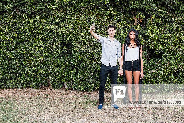 Young couple outdoors  taking selfie  using smartphone