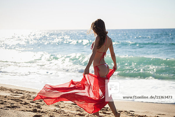 Frau am Strand im Bikini mit Sarong  Piscinas  Sardinien  Italien