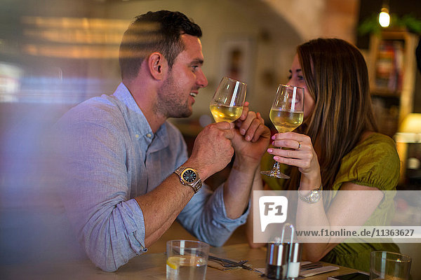 Couple toasting wine in restaurant
