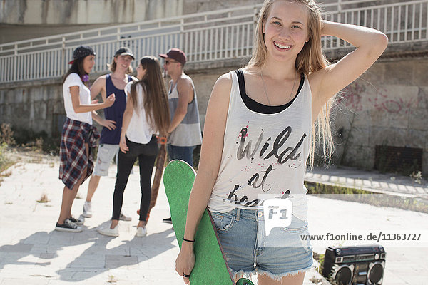 Skateboarder im Tank-Top mit wildem Herzen Slogan  Freunde im Hintergrund