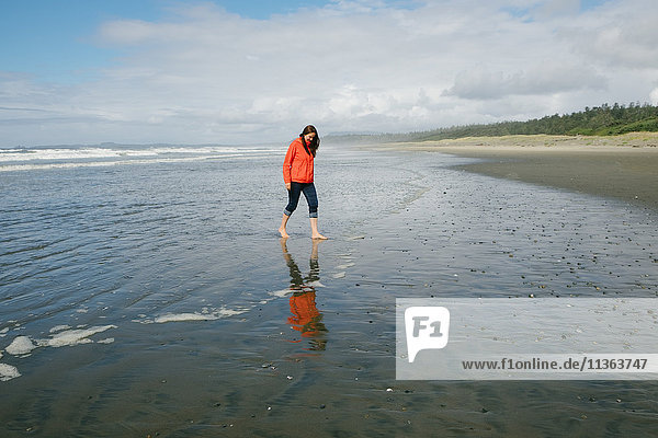 Young woman walking barefoot on beach  Long Beach  Vancouver Island  British Columbia  Canada