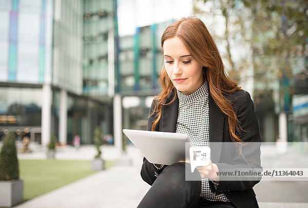 Geschäftsfrau in der Stadt  mit digitalem Tablett