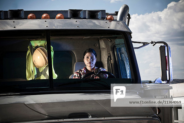 Portrait of female driver driving recycling plant truck