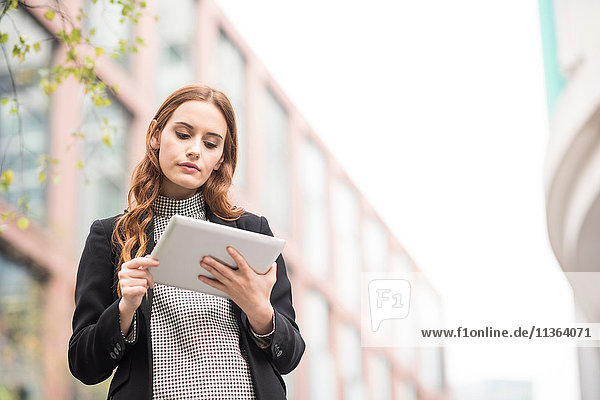 Geschäftsfrau in der Stadt mit digitalem Tablett