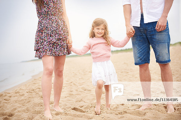 Family holding hands walking on beach