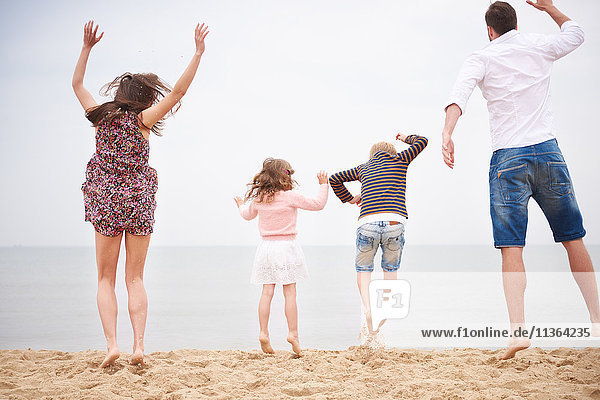 Family jumping on beach
