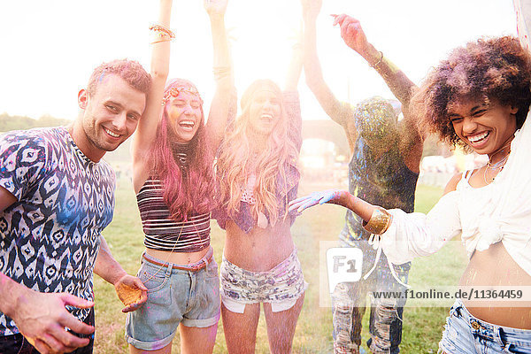 Gruppe von Freunden beim Festival  mit bunter Pulverfarbe bedeckt