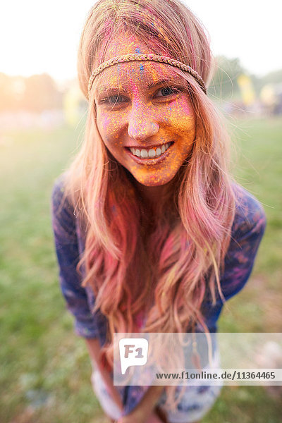Porträt einer jungen Frau beim Festival  bedeckt mit bunter Pulverfarbe