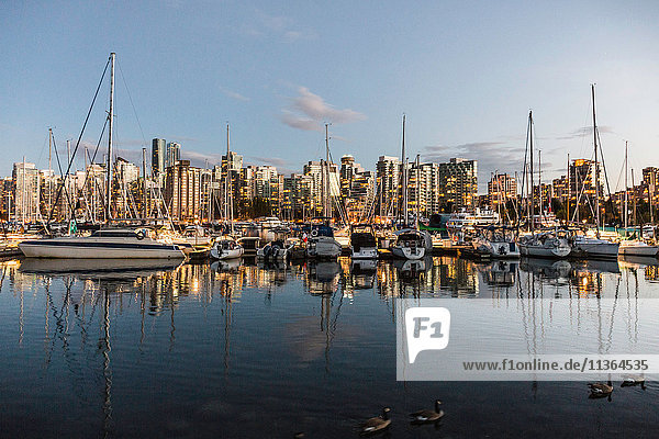 Blick auf Hafenboote und Stadtsilhouette in der Abenddämmerung  Vancouver  Kanada