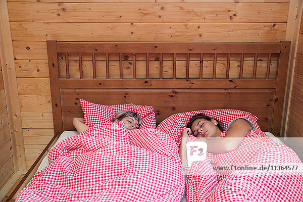 Zwei Frauen schlafen im Blockhausbett  Tirol  Österreich