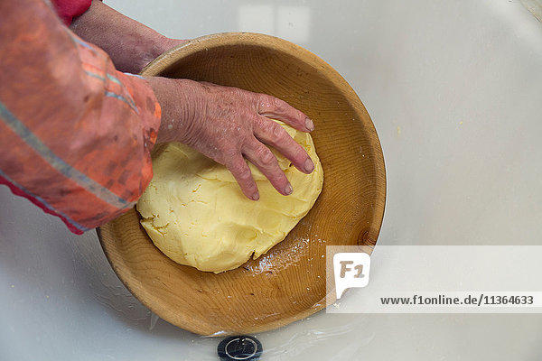 Hände einer Milchbäuerin  die Butter in einer Schüssel formt  Sattelbergalm  Tirol  Österreich
