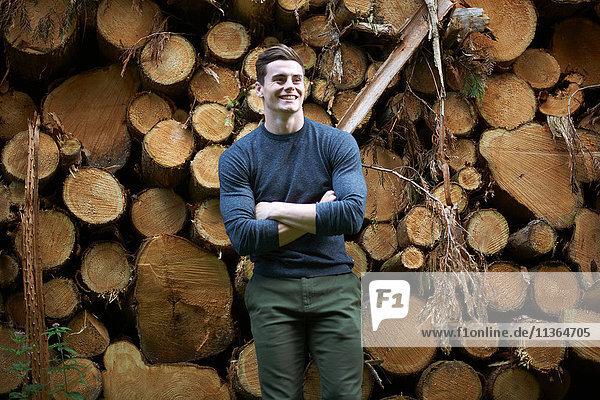 Portrait of man in front of tree trunks
