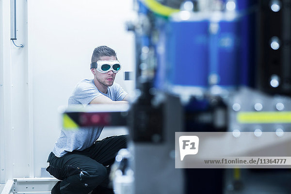 Engineer  wearing safety goggles  working in engineering plant