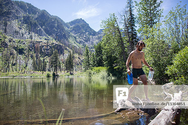 Man carrying bottles of water from stream  Enchantments  Alpine Lakes Wilderness  Washington  USA