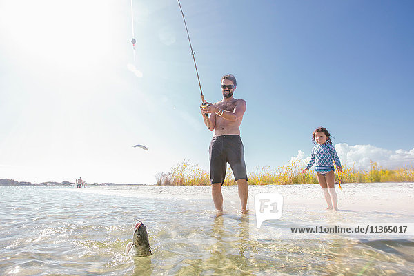 Tochter beobachtet Vater beim Fischfang im Meer  Fort Walton Beach  Florida  USA