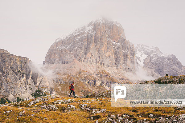 Hiker walking  Mount Lagazuoi in background  Dolomite Alps  South Tyrol  Italy
