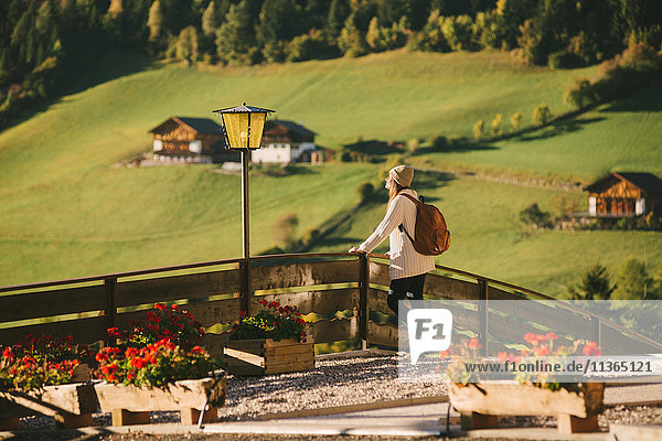 Woman enjoying view by wooden fence  Santa Maddalena  Dolomite Alps  Val di Funes (Funes Valley)  South Tyrol  Italy