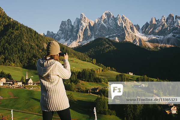 Woman taking photograph  Santa Maddalena  Dolomite Alps  Val di Funes (Funes Valley)  South Tyrol  Italy