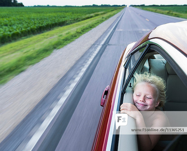 Windgepeitschter Junge im Auto Augen lächelnd geschlossen