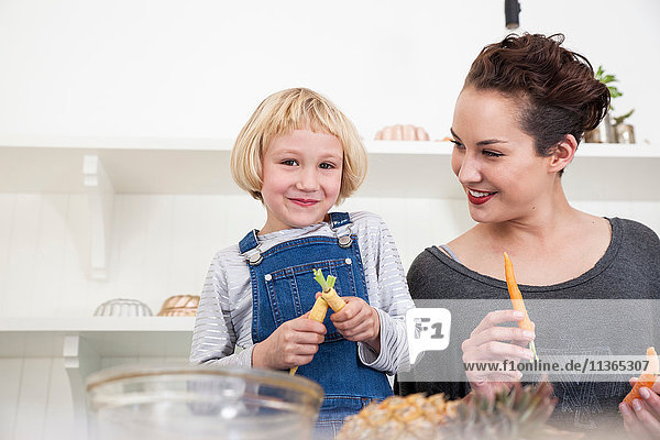 Young woman and girl in kitchen  preparing food