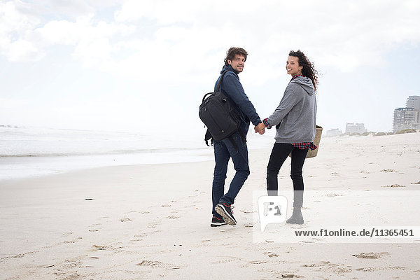Rear view portrait of young couple strolling on beach  Western Cape  South Africa