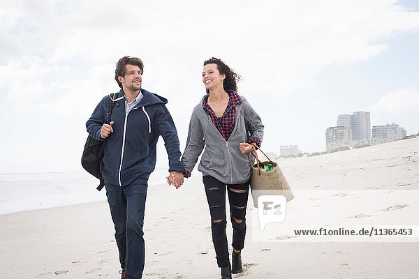 Romantic young couple strolling on windswept beach  Western Cape  South Africa