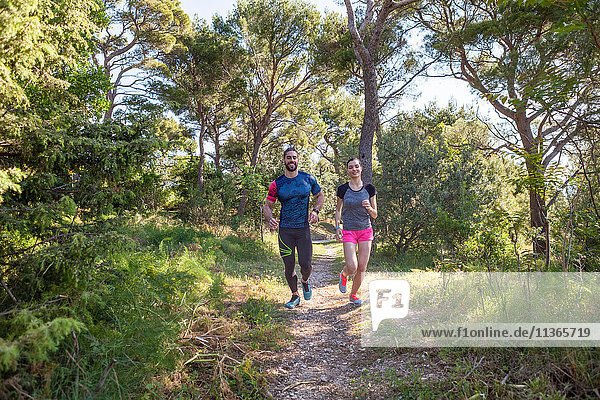 Male and female runners running in park  Split  Dalmatia  Croatia