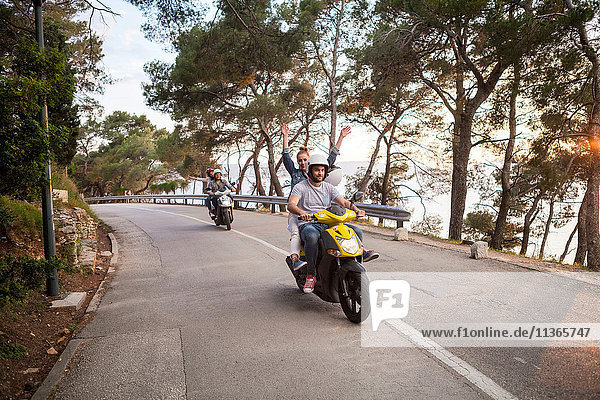 Two couples riding mopeds on rural road  Split  Dalmatia  Croatia
