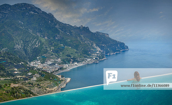 Rückansicht einer Frau  die vom Infinity-Pool auf die Küste schaut  Ravello  Amalfiküste  Italien
