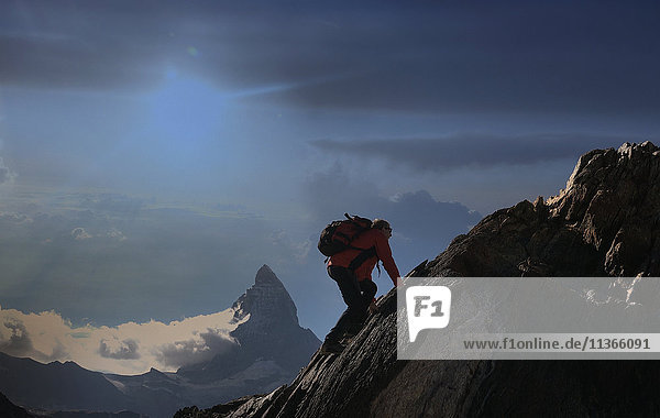 Älterer männlicher Bergsteiger klettert an einer Felswand in der Nähe des Matterhorns  Kanton Wallis  Schweiz