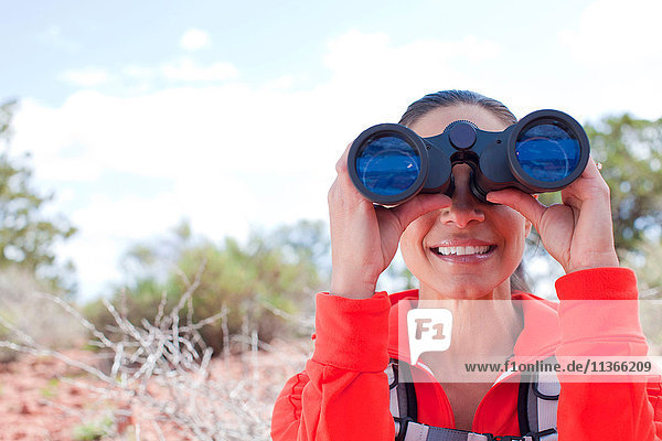 Porträt einer reifen Frau  die durch ein Fernglas schaut  Sedona  Arizona  USA