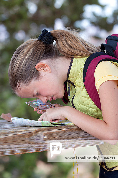 Girl peering at map with magnifier  Sedona  Arizona  USA