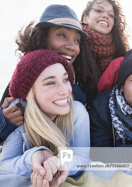 Junge erwachsene Freunde übereinanderliegend am Strand Western Cape Südafrika