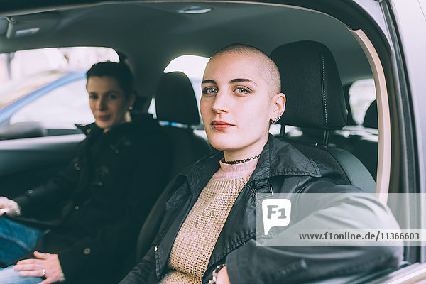 Portrait of young lesbian couple sitting in car
