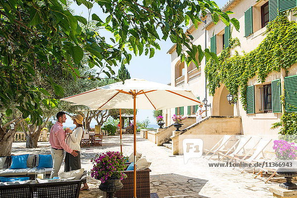Couple talking on patio at boutique hotel  Majorca  Spain