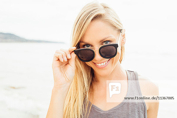 Portrait of woman wearing sunglasses looking at camera smiling