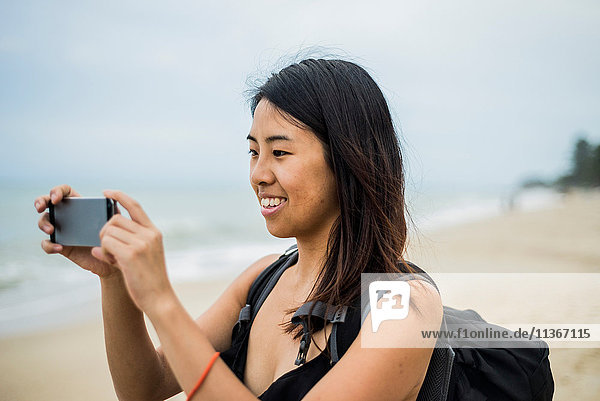 Young woman taking photograph at Lammai Beach  Koh Samui  Thailand