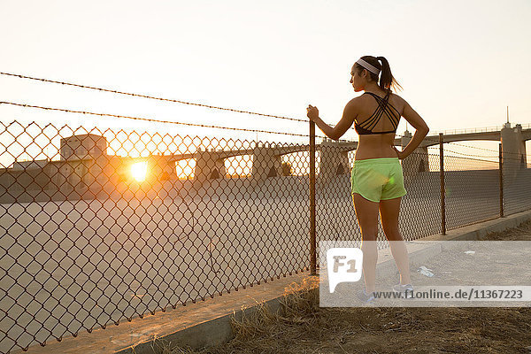 Athletin träumt bei Sonnenuntergang am Drahtzaun  Van Nuys  Kalifornien  USA
