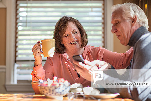 Seniorenpaar sucht Smartphone-Update am Küchentisch