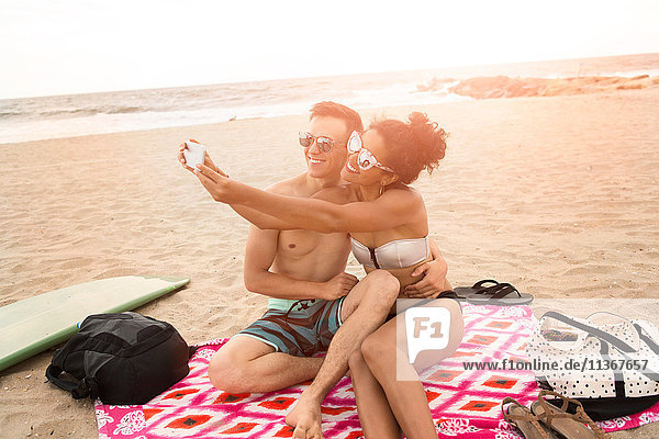 Junges Paar beim Smartphone-Selfie am Rockaway Beach  New York State  USA