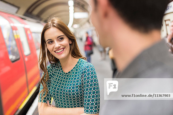 Woman on railway platform talking to friend