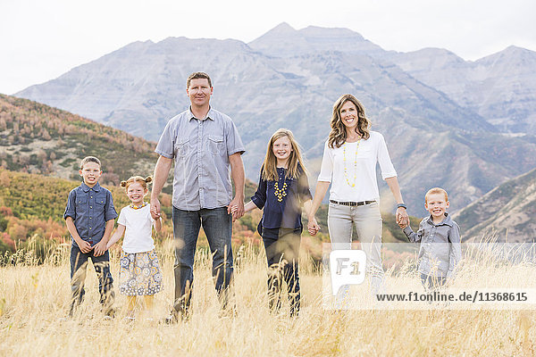 USA  Utah  Provo  Family with three children (4-5  6-7  8-9) standing in field