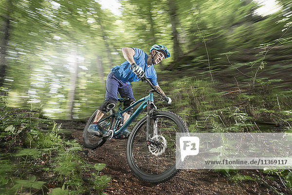 Mountain biker riding downhill in forest