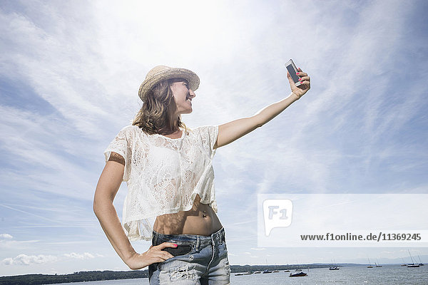 Woman taking selfie at the lake  Ammersee  Upper Bavaria  Germany