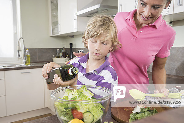 Woman with her son preparing salad in kitchen