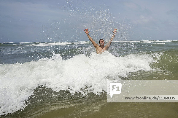 Waves splashing on man in sea Western Province Sri Lanka
