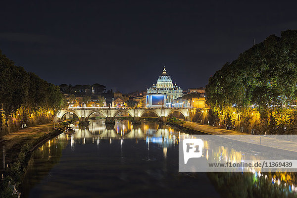 Illuminated St. Peter's Basilica by bridge over river at night  Rome  Italy