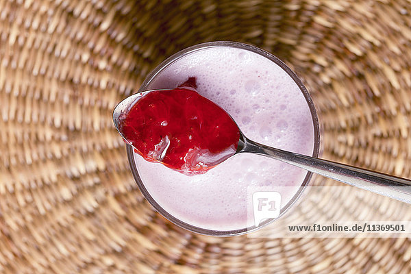 Close-up of strawberry jam with yoghurt jar on basket