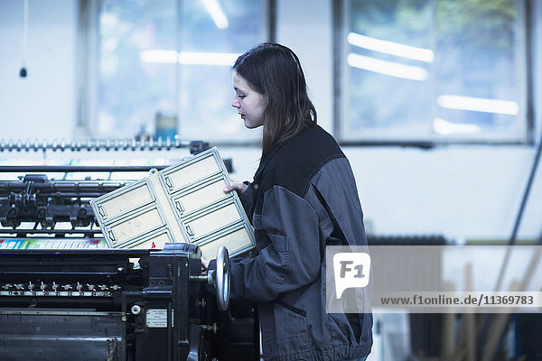 Druckereiarbeiter beim Einstellen einer Druckmaschine in einer Industrie