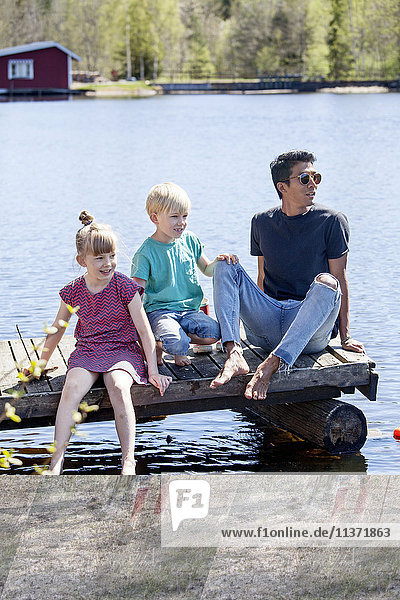 Father with children relaxing at lake